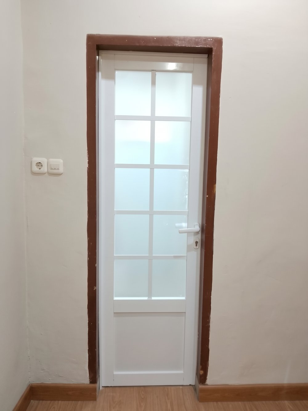 Pintu ACP putih kombinasi kaca buram berkisi di bagian atas dan panel ACP di bagian bawah